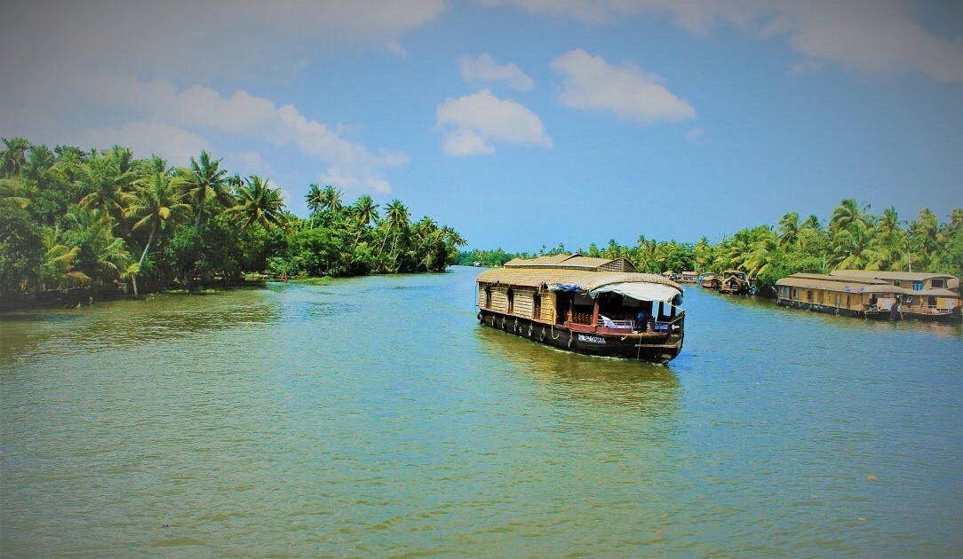 Kerala houseboat on Alleppey backwaters with palm trees
